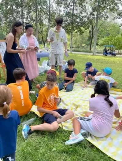 Students sitting on picnic blankets outdoors during a Mandarin class